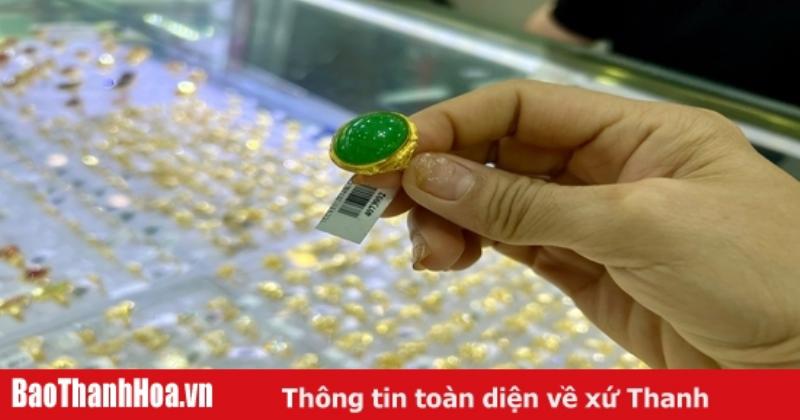 Hình ảnh một người đang kiểm tra vàng miếng hoặc nhẫn vàng bằng mắt thường và giấy tờ