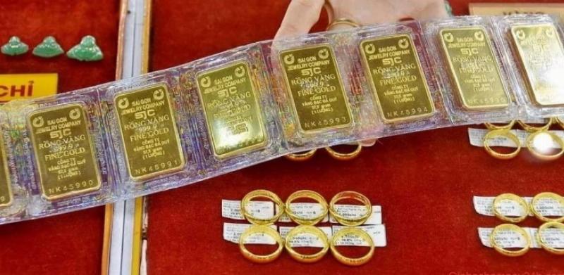 Một người đang cẩn thận cất giữ các miếng vàng nhỏ hoặc nhẫn vàng vào hộp hoặc két sắt