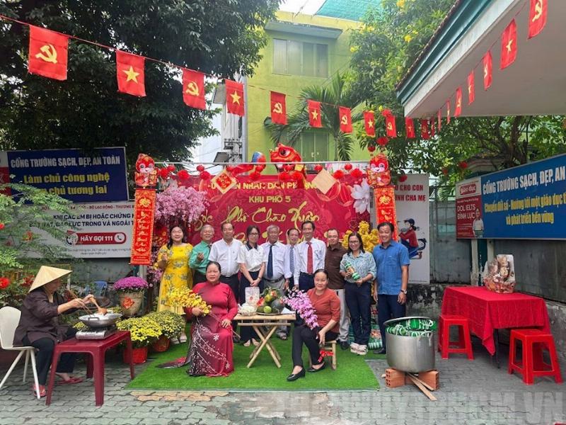 Hình ảnh một góc nhà được trang trí Tết với hoa mai/đào, câu đối đỏ, đèn lồng.